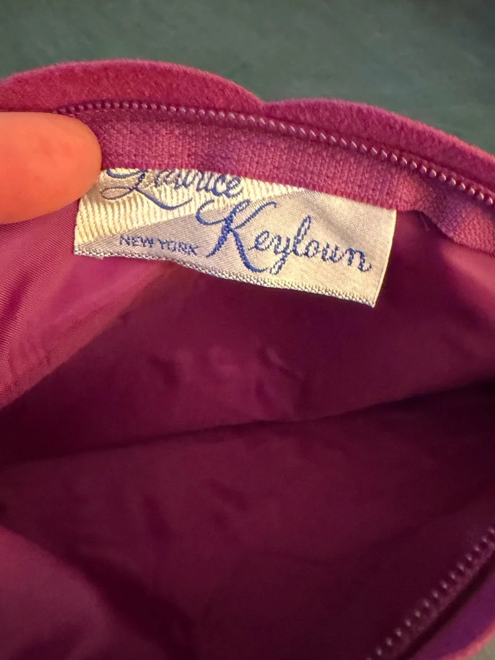 Maurice Keyloun New York magenta cosmetic pouch with zipper closure.
